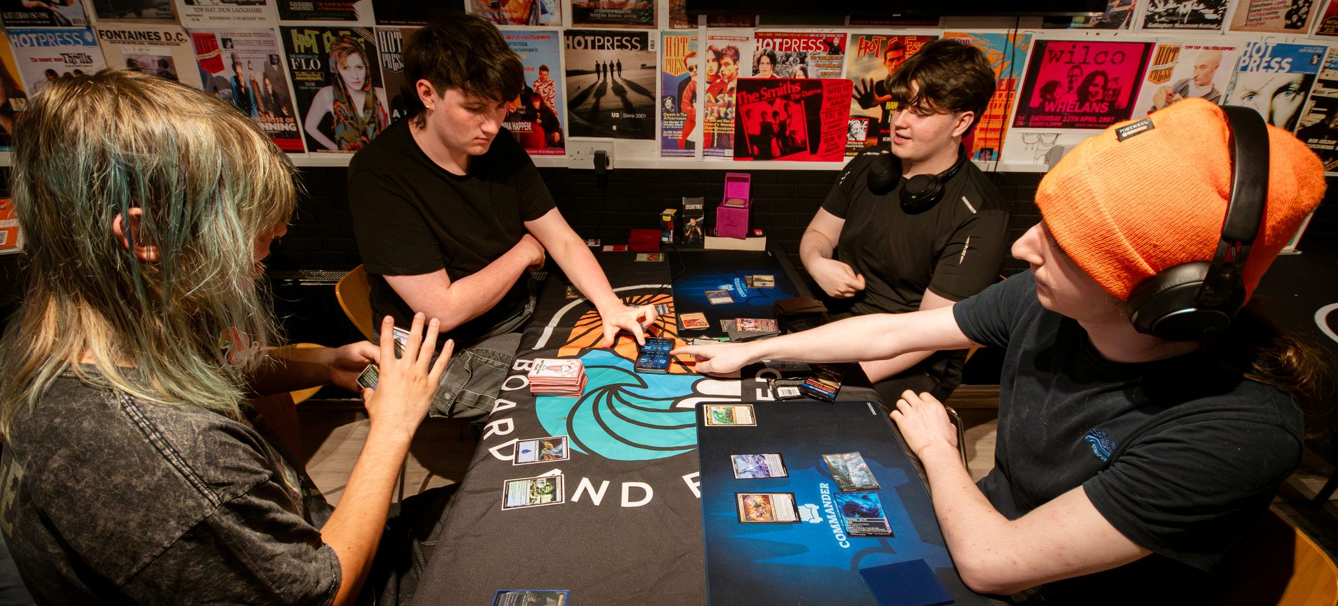 Players mid-game at a Board & Brewed card game night
